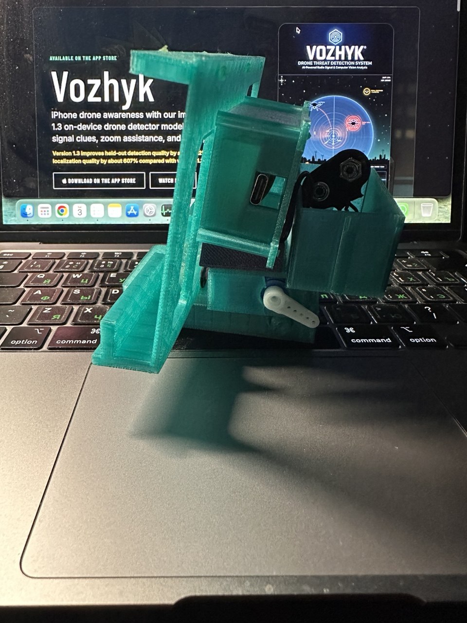Side view of the green 3D-printed Vozhyk Picatinny attachment prototype